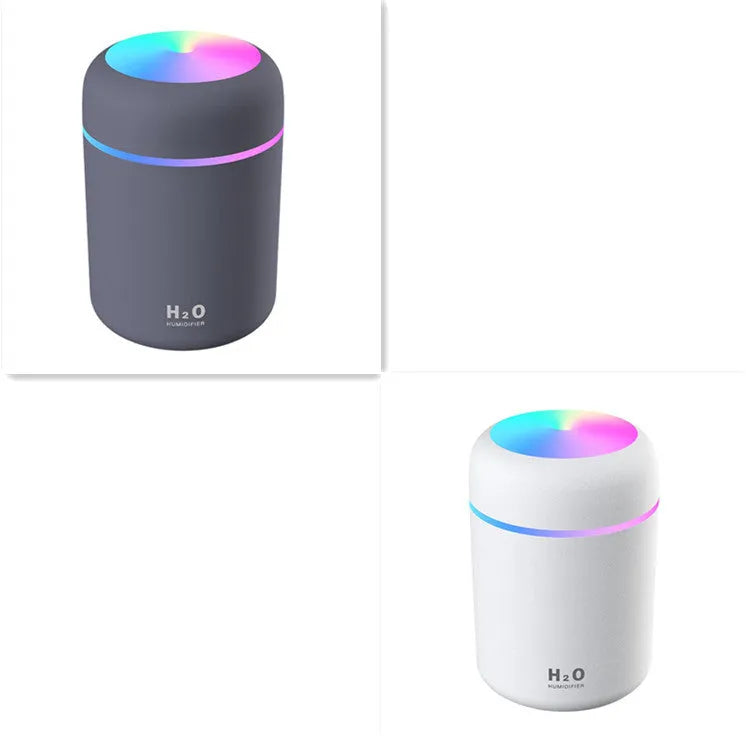 Pink USB desktop humidifier with LED lights and water tank on wooden desk
