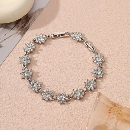 Gold and silver electroplated bracelets with flower charms set with coloured gemstones.