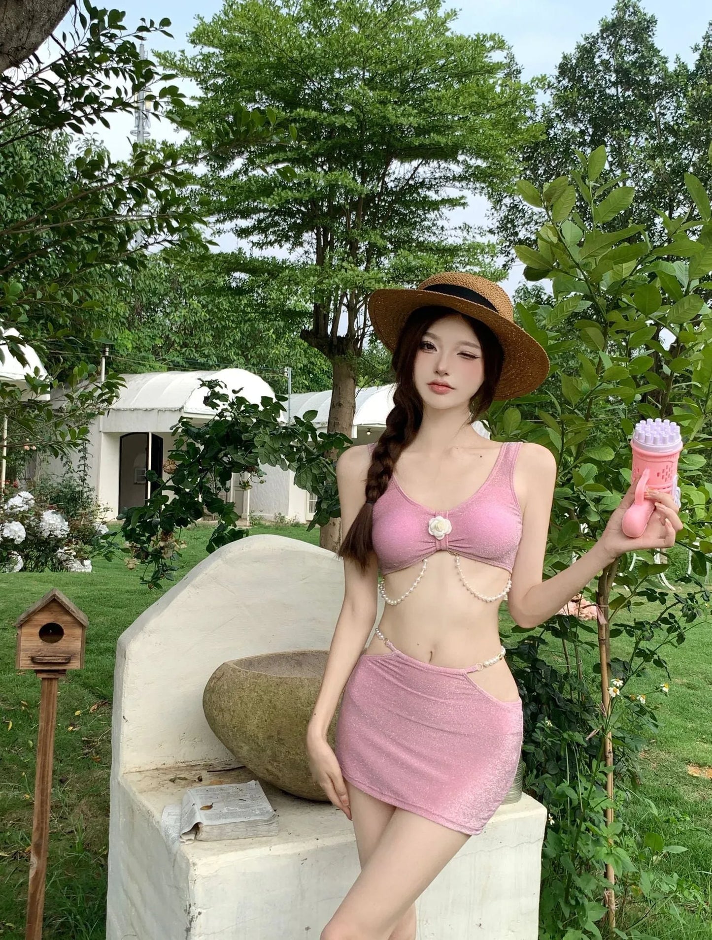 Pink and black polyester three-piece bikini swimsuit on a mannequin