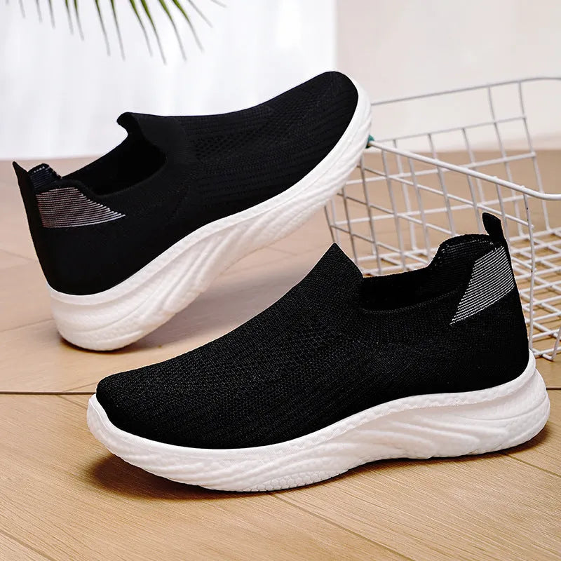Women's Flyknit casual running shoes with soft PVC sole in black, grey, pink, and blue colour options.