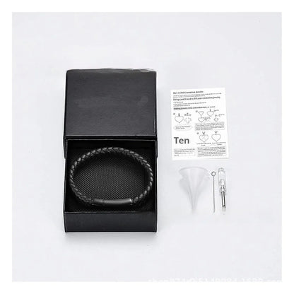 Black leather and stainless steel cinerary bracelet with personalised English letters, presented in a gift box.