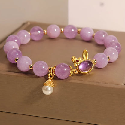 Natural mauve jade rabbit head charm bracelet with crystal details on wrist.