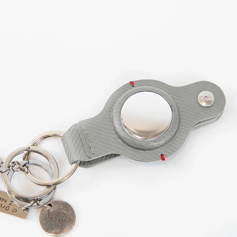 Premium PU leather AirTag keychain holder in black and grey colors for secure tracking of valuables