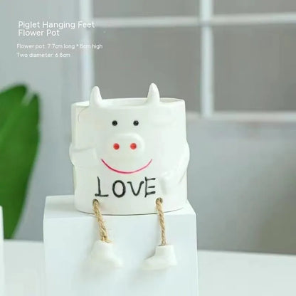 Ceramic hanging foot flowerpot with cartoon design for succulents on desktop