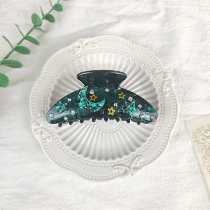 Oversized star barrettes in starry sky colours showing minimalist design and irregular elements