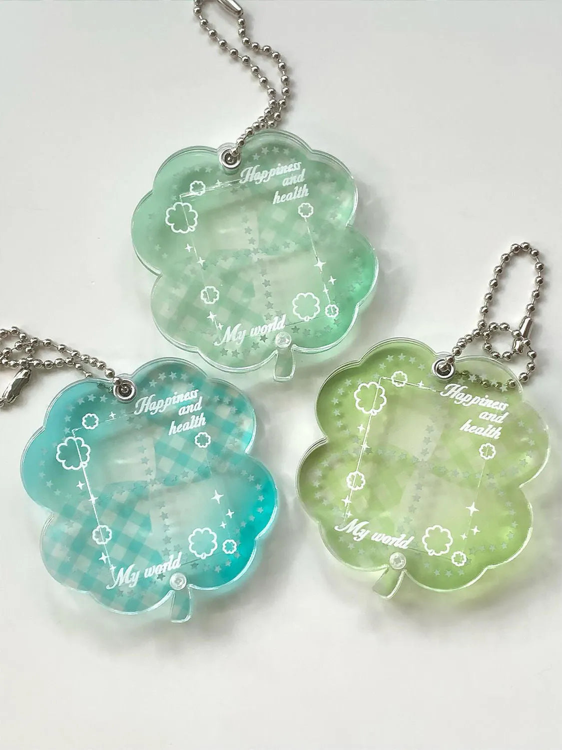 Four-leaf clover shaped acrylic phone pendant keychain in blue, green, and mint colour options