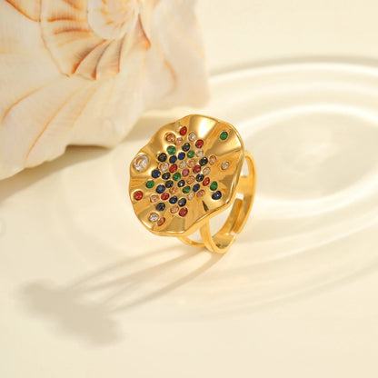 Geometric open-mouth stainless steel ring with pleated inlaid colour diamonds on a white background.
