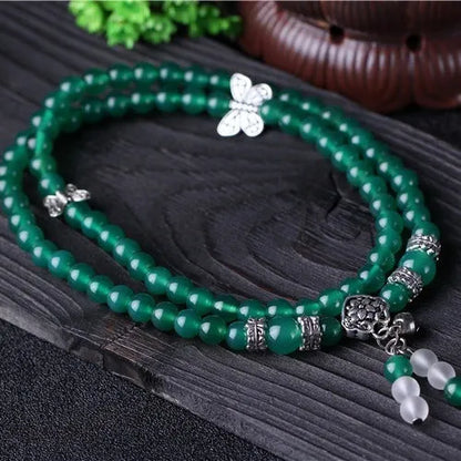 Close-up of a green agate multi-layer chain bracelet with three strands of 6mm beads.