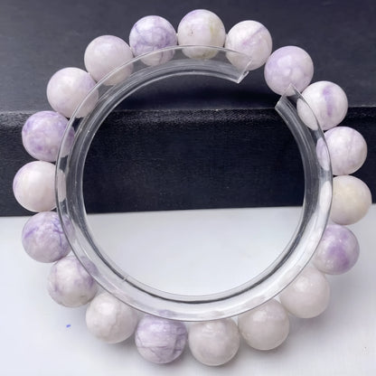 Close-up of a purple turquoise gemstone bead bracelet with an adjustable leather cord fastening.