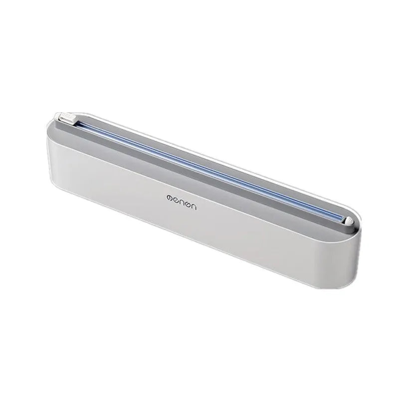 Black plastic cling film cutter and dispenser unit mounted on a refrigerator door.