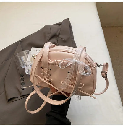 Women's PU leather casual shoulder handbag with a large bandage bow and sewing thread detail.