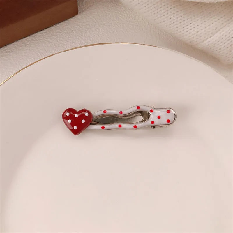 Red love heart-shaped hair barrette clip with retro white dots on a willow leaf-shaped base.