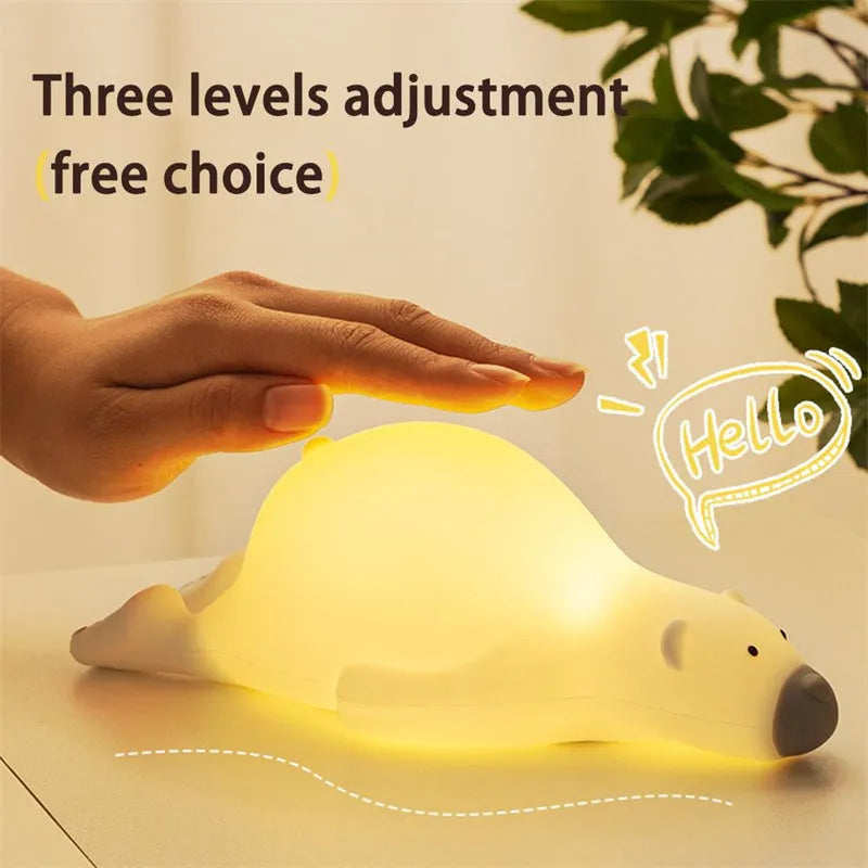 White bear-shaped silicone night light on a table with USB cable.