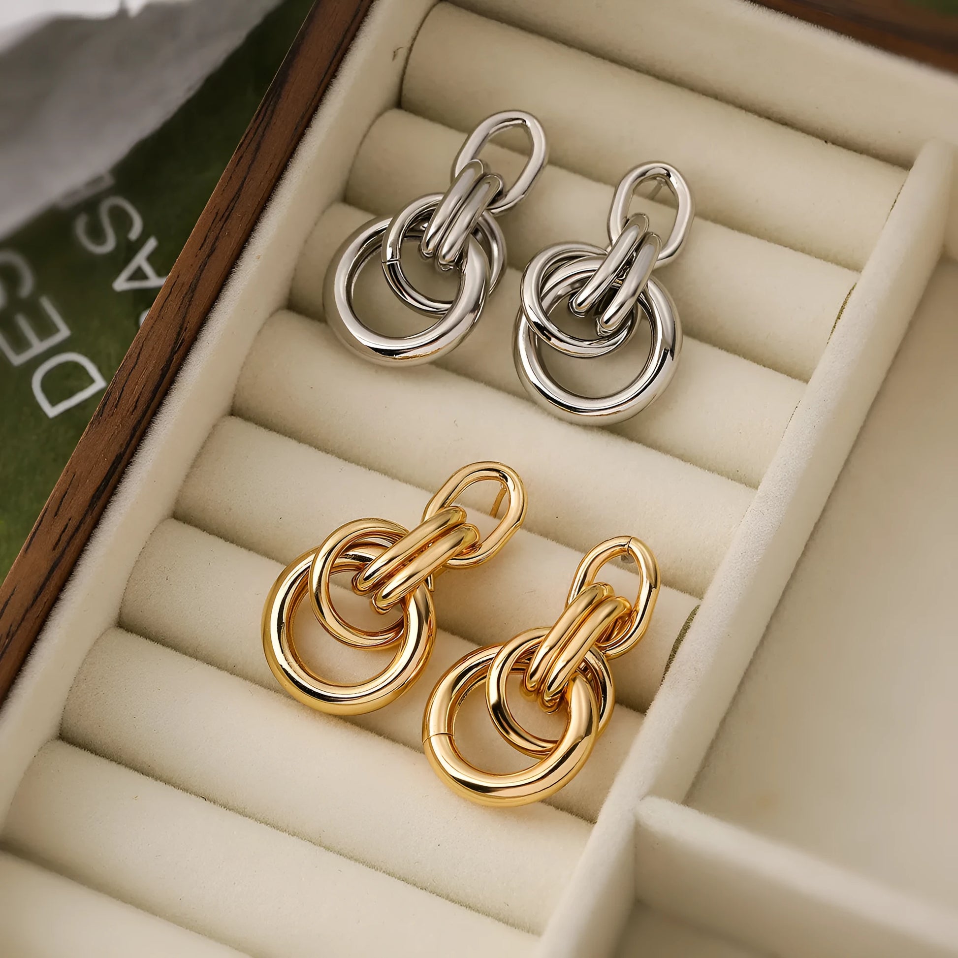 A pair of gold-coloured geometric drop earrings with irregular shapes, made from copper.