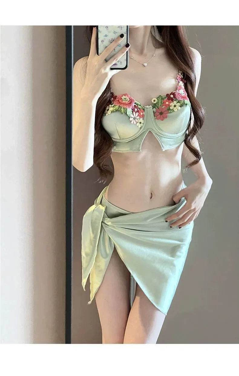 Green women's bikini three-piece set with triangle top, pants, and skirt