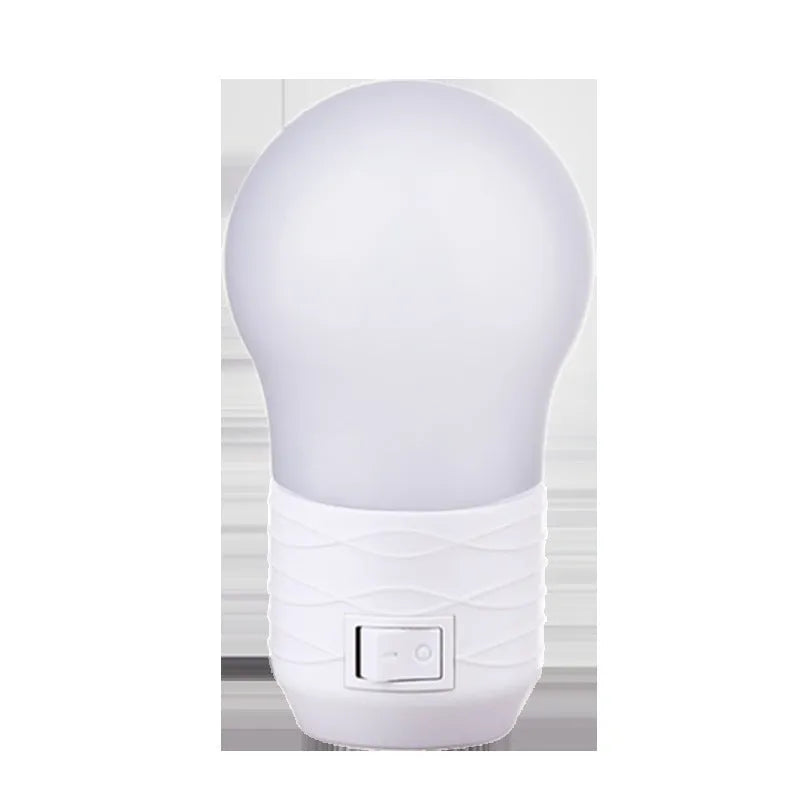 Plug-in bedside baby night light in white, blue, or pink shell with round shape.