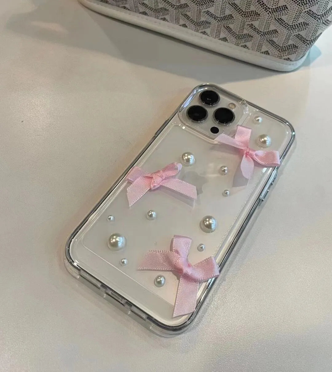 Transparent TPU iPhone case with three-dimensional pearl bow, anti-fall all-inclusive design, colour-matching finish