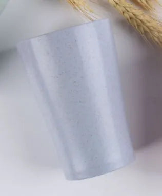 A cylindrical wheat straw plastic bathroom cup in a Nordic colour, holding toothbrushes.