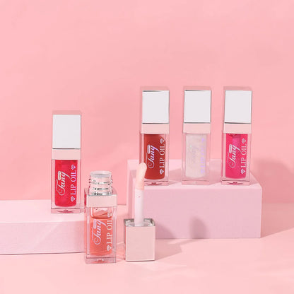 Set of five bright lip gloss tubes with lip essence oil applicators in shades Style001, 006, 007, 012, and 015.
