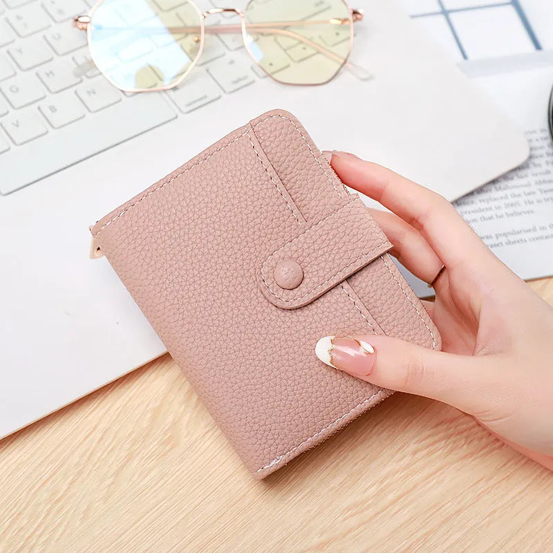 Women's solid colour PU short wallet in beige, showing lychee pattern and sewing thread detail.