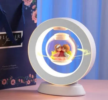 Pink rose eternal flower floating in magnetic levitation LED night light with triangular base and touch control
