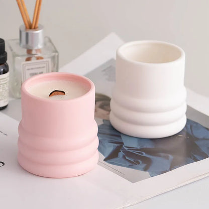 Set of ten round white ceramic candlesticks with minimalist relief patterns on a dining table