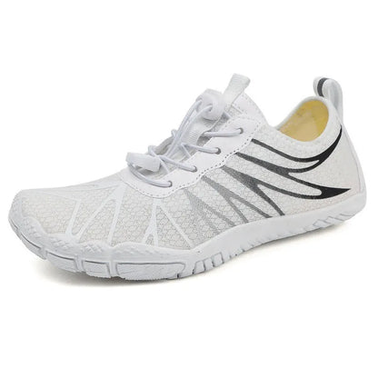 Men's and women's low-top breathable sports running shoes with a natural rubber sole on a hard ground surface.