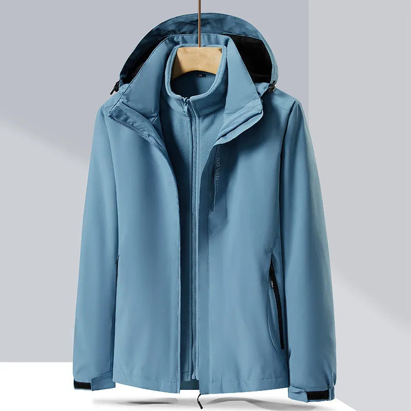 Men's fluorescent coloured waterproof mountaineering suit with removable fleece liner, shown in a hiking setting.
