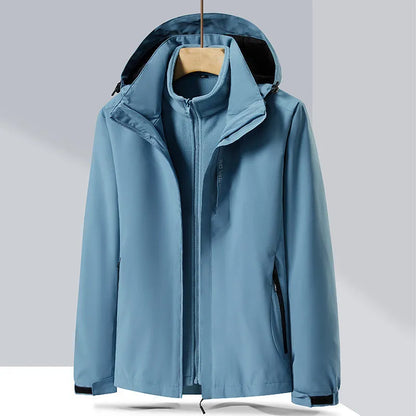 Men's fluorescent coloured waterproof mountaineering suit with removable fleece liner, shown in a hiking setting.