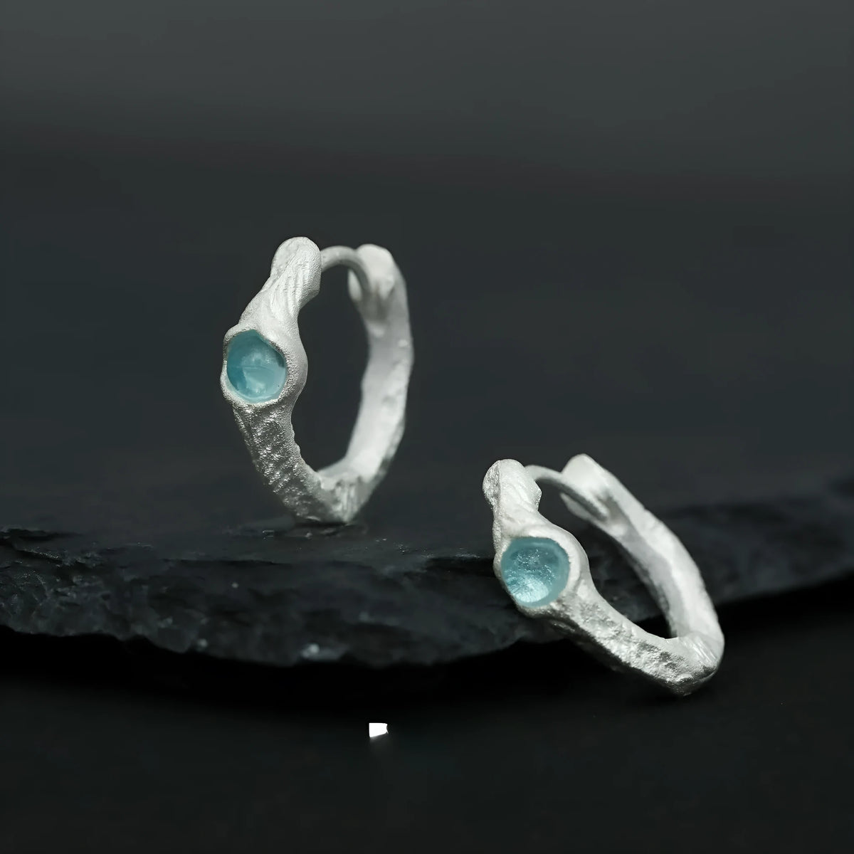 Geometric burnt silver sterling silver ear clip for women on a plain background.