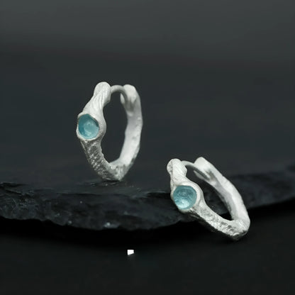 Geometric burnt silver sterling silver ear clip for women on a plain background.
