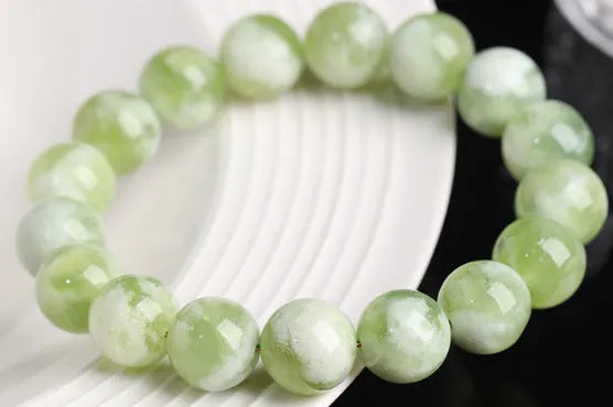 Green milk-in-water Xiuyan jade bracelet with polished geometric beads.