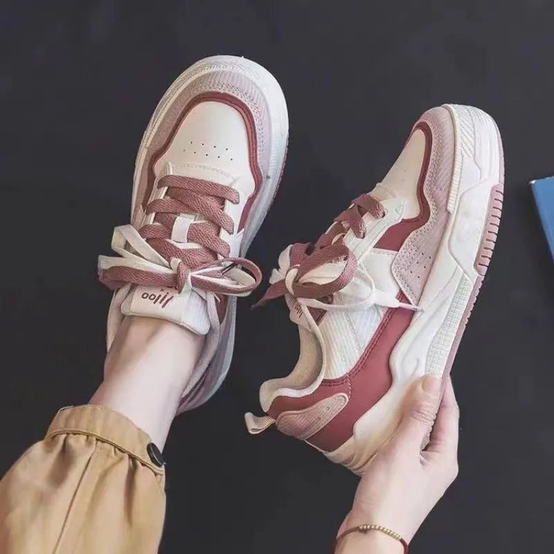 Pink and milky white low-top height-increasing sneakers with a rubber sole.