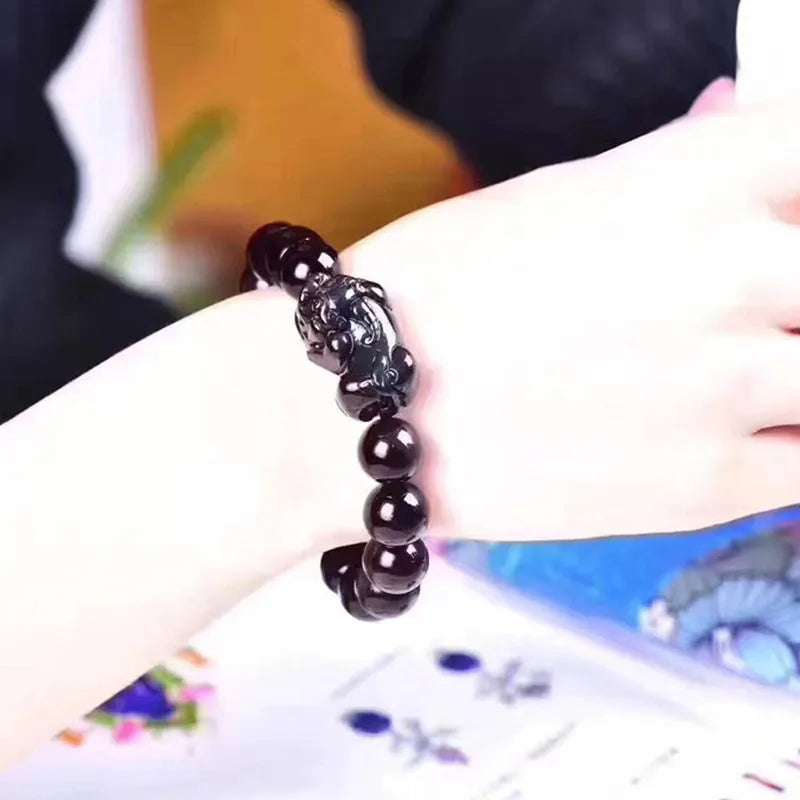 Natural Ice Colour Eye Obsidian crystal bracelet on wrist, showing translucent beads.