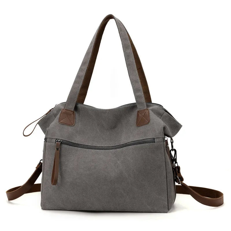 Large grey retro-style canvas shoulder bag with a horizontal square shape and multiple internal pockets.