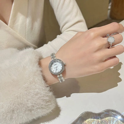 Women's vintage freshwater pearl bracelet watch with 25mm dial, steel strap, and double row pearl design in silver