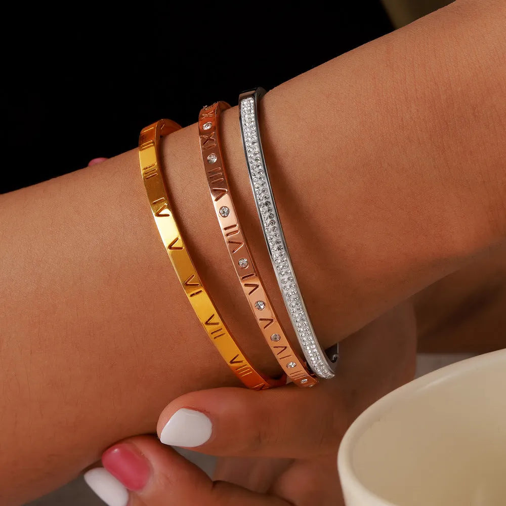 Titanium steel Roman numeral bracelet with gold plated carved design and diamond-embedded detail