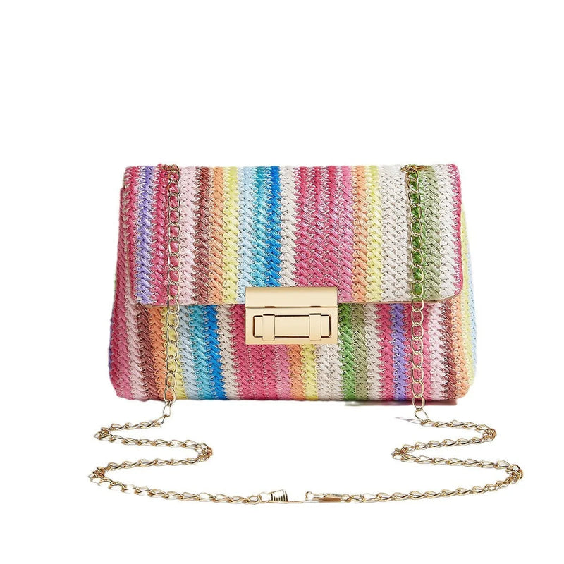 Women's cross-body bag made from natural straw material in a small square shape with a secure lock closure, featuring a single shoulder strap, internal mobile phone compartment, and no lining cloth, available in rainbow colour, khaki, and blue options.