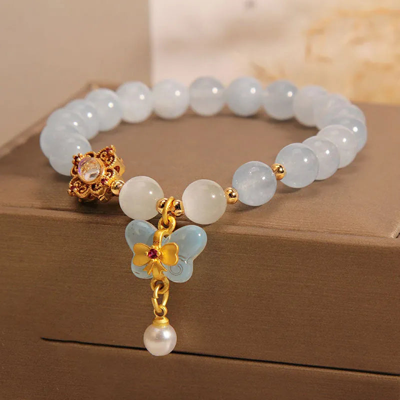 Women's crystal bracelet with a blue aquamarine butterfly pendant and rhinestone details.
