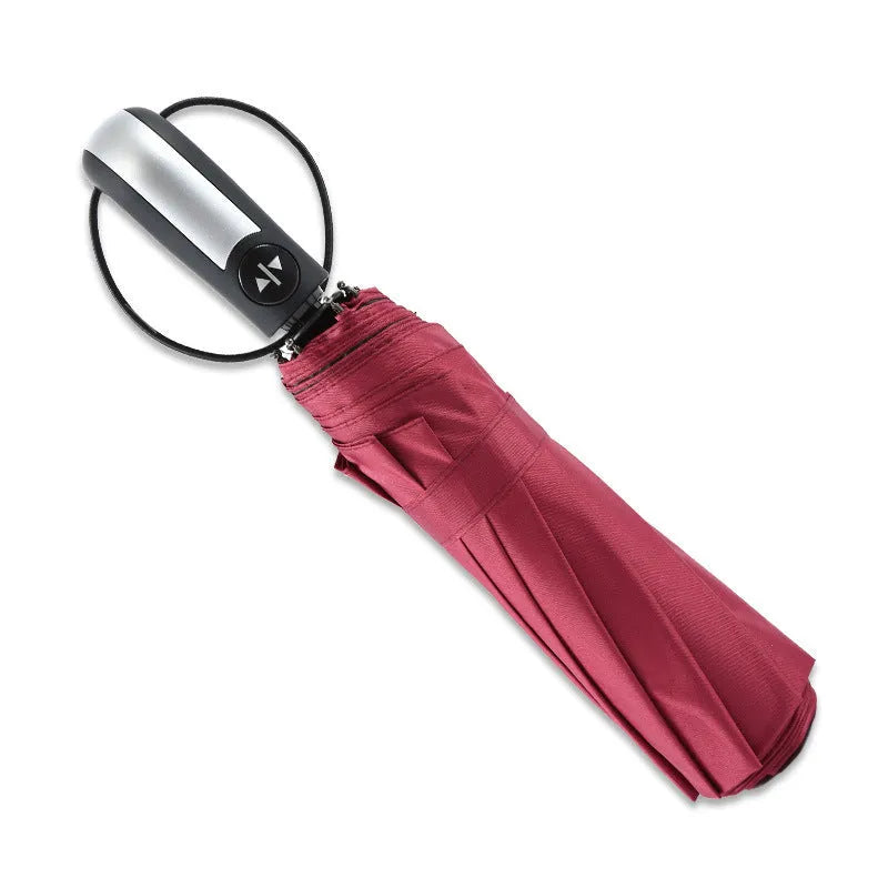 Triple-folding automatic sun-shade umbrella in black with steel ribs and rubber handle, showing compact folded size.