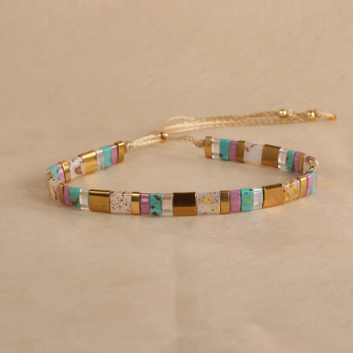 Geometric glass beaded pull bracelet in multiple colours including milky white, black, retro green, light blue, and red