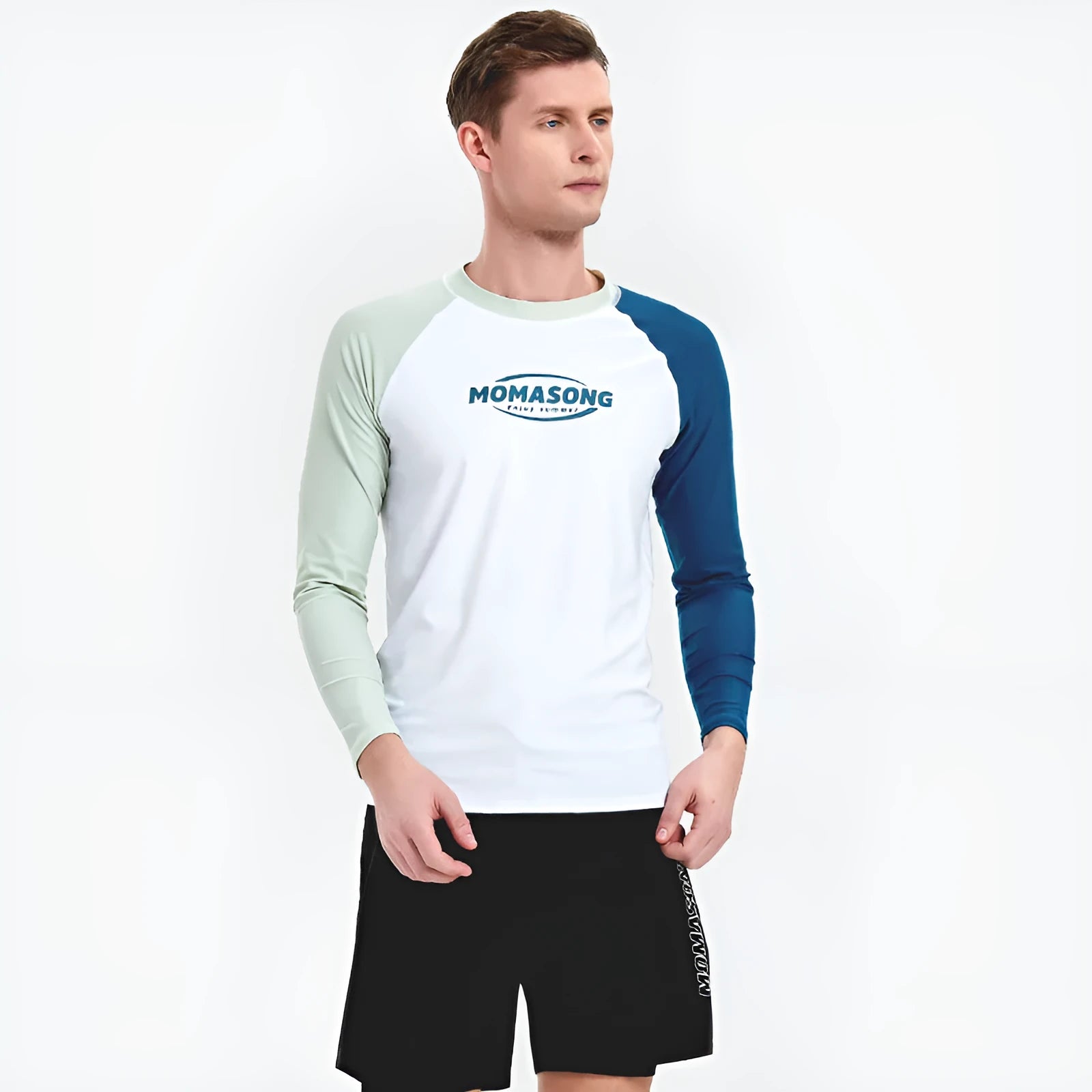 Man wearing a white long-sleeved swim top and matching blue swim trunks at the beach.