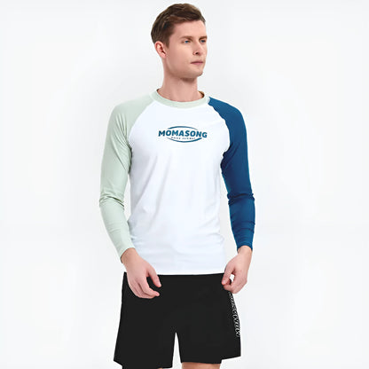 Man wearing a white long-sleeved swim top and matching blue swim trunks at the beach.