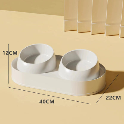 White elevated pet feeder with two tilted bowls on a non-slip base, for cat and small dog food and water.