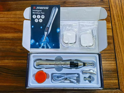 Rechargeable charging acupuncture pen with five massage heads and USB cable on a table.