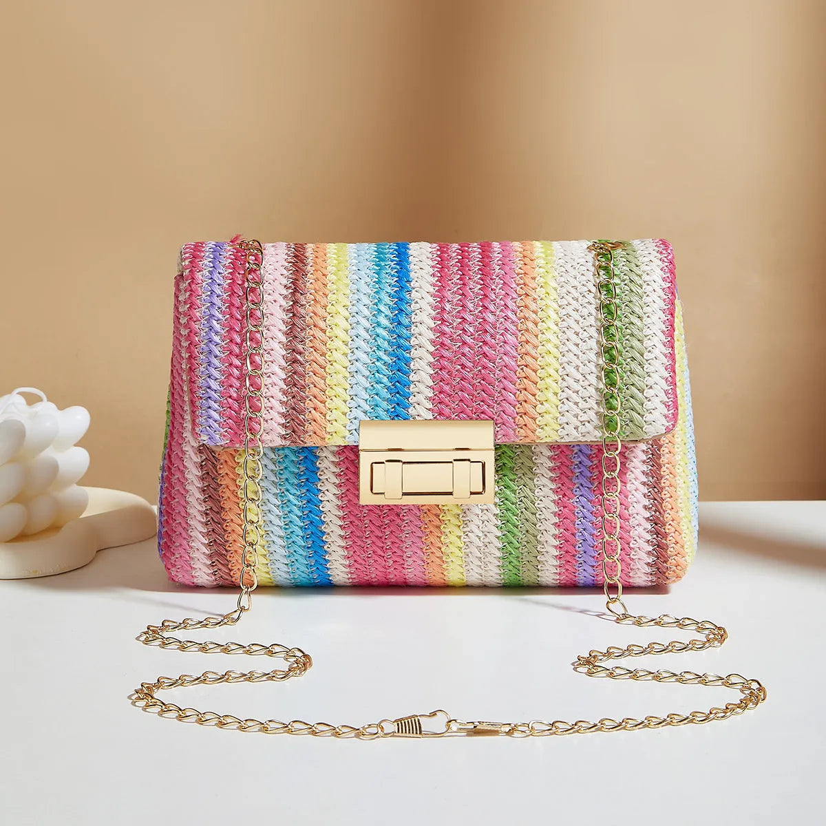 Women's small square straw cross-body bag with lock closure, shown in rainbow colour.