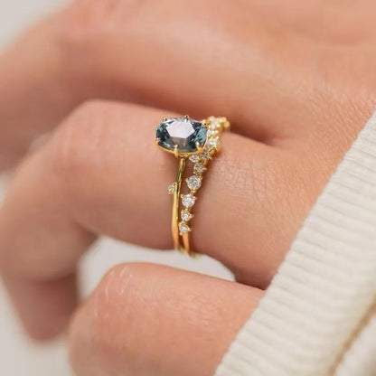 Gold-plated floral women's ring with a green zircon stone centrepiece on a model's hand.