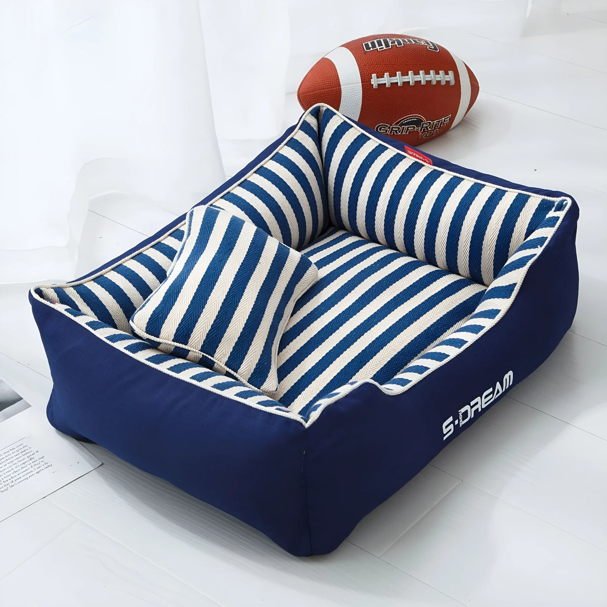 Removable washable dog kennel mat with fabric pillow in navy stripes and blue or red colour options.