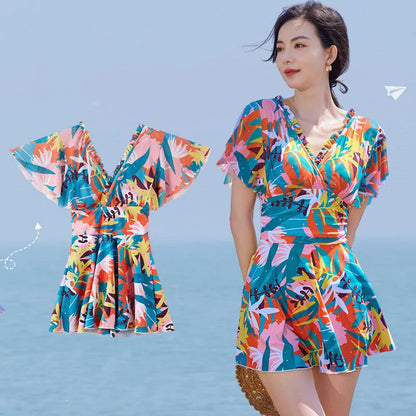 Women's colourful printed one-piece swimsuit on a mannequin, showing full coverage design.