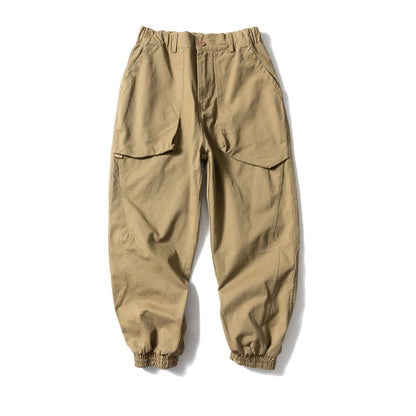 Solid colour cotton casual pants with large pockets and a tapered, ankle-tied silhouette.